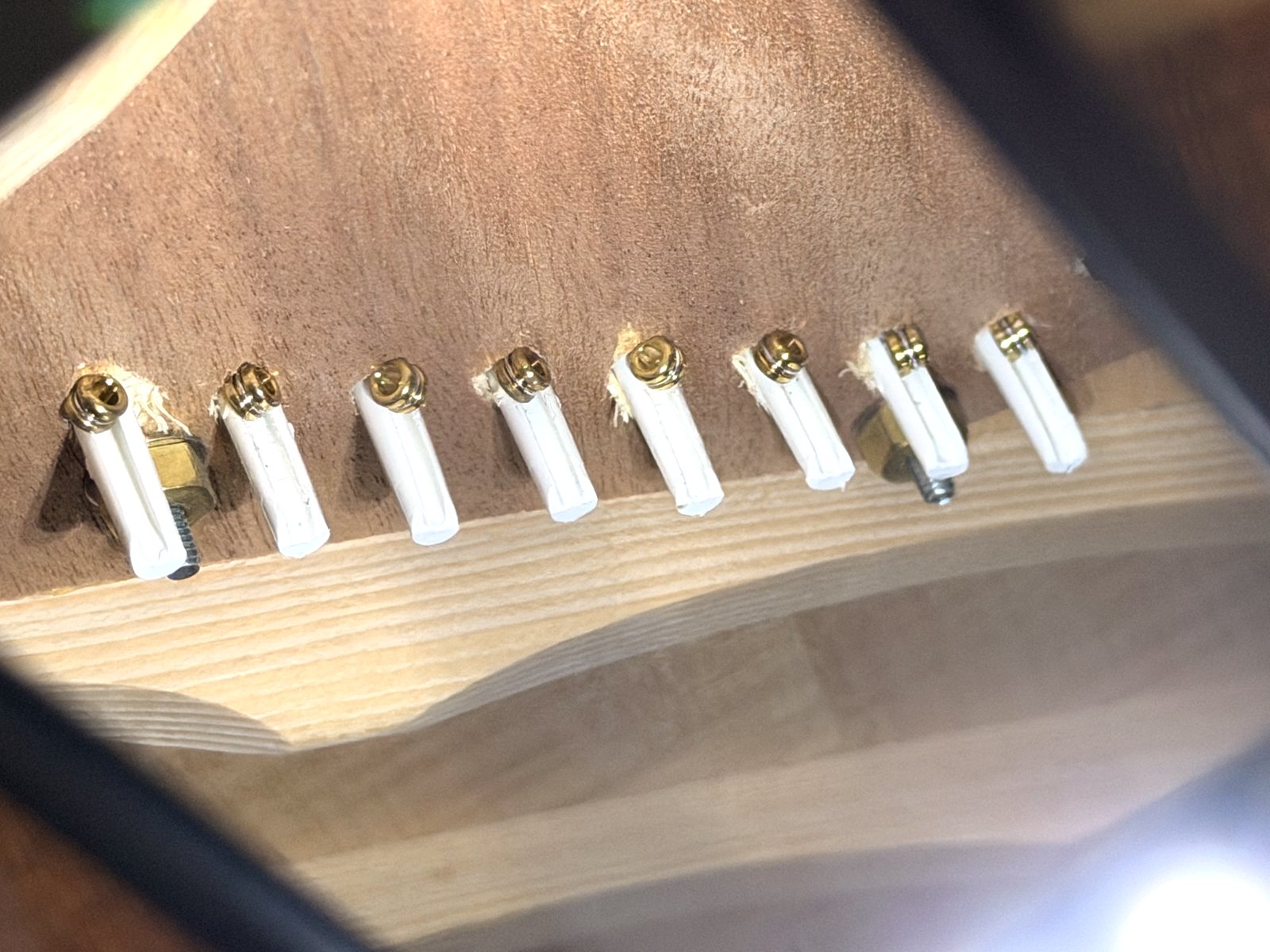 The same bridge plate after filing the pin: all eight ball ends, including the Stringjoy .090’s at the right end, sit snugly against the plate beside their pins.